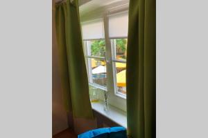 una ventana con cortinas verdes en una habitación en In the Heart of the Island, en Lindau