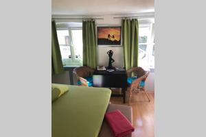 ein Wohnzimmer mit grünen Vorhängen sowie einem Tisch und Stühlen in der Unterkunft In the Heart of the Island in Lindau