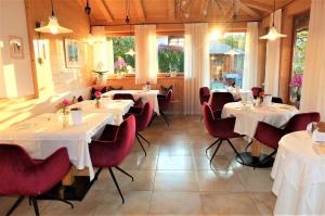 ein Restaurant mit weißen Tischen und roten Stühlen in der Unterkunft Tirolerhof Pension in Natz-Schabs