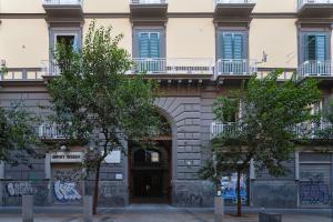 una entrada a un edificio con árboles delante de él en Skyhouse Duomo, en Nápoles