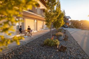 two people sitting on a sidewalk next to a building at Landgasthof Deutsches Haus KG in Weilheim an der Teck