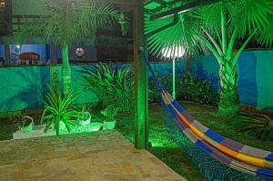 a hammock in a room with palm trees at Casa azul Ilha Grande in Abraão