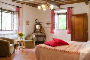 Un dormitorio con una cama con almohadas rojas. en Tenuta di Casaglia, en Podere Colombaie