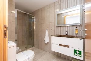 a bathroom with a toilet and a sink and a mirror at Feel Porto Corporate Housing Marquês in Porto +18 photos