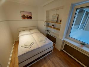 um pequeno quarto com uma cama e uma janela em Overnight Apartment em Colônia