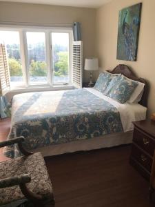 a bedroom with a bed and two windows at Butterfly Manor in Niagara Falls