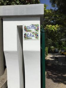 een bord aan de zijkant van een wit hek bij Villa Lilia in Vietri