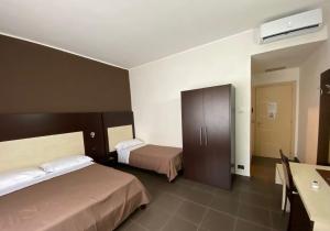 een hotelkamer met 2 bedden en een bureau bij Pansini Hotel Residence in Badolato