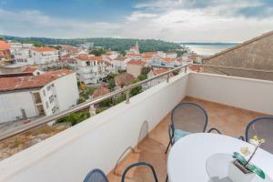 a balcony with tables and chairs overlooking a city at Apartments & Rooms Alagić in Makarska