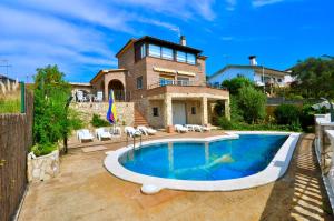 una casa con piscina frente a una casa en VILLA EVA, en Vidreres