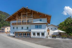 a large white building with a wooden roof at Home-Hotel Salzberg in Berchtesgaden