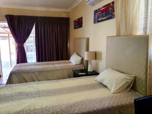 Łóżko lub łóżka w pokoju w obiekcie Tenacity Guesthouse - Riviera Park