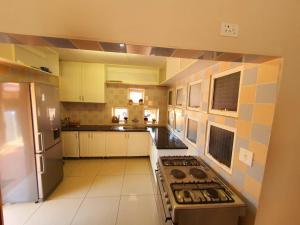 uma grande cozinha com um fogão e um frigorífico em Tenacity Guesthouse - Riviera Park em Mahikeng
