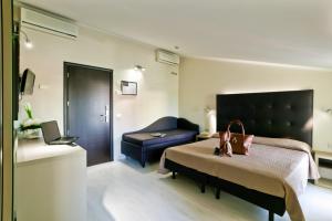 ベッラーリア・イジェア・マリーナにあるHotel Theaのベッドとソファ付きのホテルルーム
