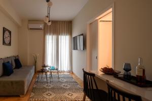 ein Wohnzimmer mit einem Sofa und einem Tisch in der Unterkunft Acropolis Grand Apartment in Athen