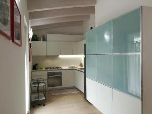 kuchnia z białymi szafkami i szklaną ścianą w obiekcie Ferrarini w mieście Riva del Garda