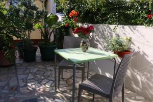 d'une table avec deux chaises et d'un vase avec des fleurs. dans l'établissement Vivenda Barroso, à Nazaré