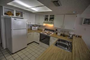 a kitchen with a white refrigerator and a sink at SURFSIDE II 107 condo in South Padre Island
