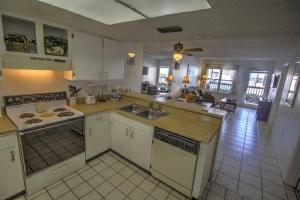 a kitchen with a sink and a stove top oven at SURFSIDE II 107 condo in South Padre Island