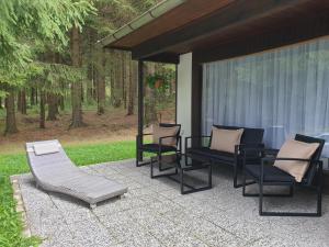 - un ensemble de chaises et de tables sur une terrasse dans l'établissement Waldhotel Rennsteighöhe, à Frauenwald