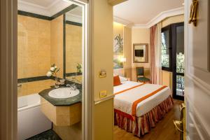 Cette chambre comprend un lit, un lavabo et une baignoire. dans l'établissement Donna Laura Palace by OMNIA hotels, à Rome