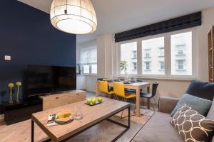 a living room with a couch and a table at Nowogrodzka 38 Serviced Apartments in Warsaw