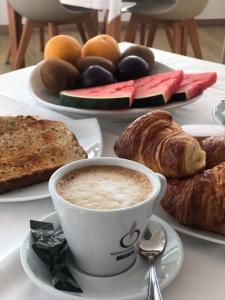 a table topped with a cup of coffee and pastries at Hotel Llorca in Platja de l’Almadrava