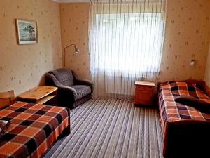 una habitación de hotel con 2 camas y una silla en Svētgravas, en Aklaisciems