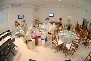 ein großes Zimmer mit Tischen und Stühlen mit Blumen darauf in der Unterkunft Vale Verde Palace Hotel in Laranjal Paulista
