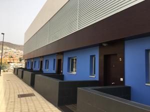 a row of blue buildings on a street at Cornisa Apartments in Patalavaca