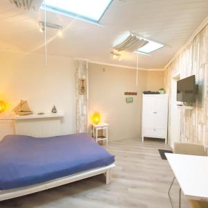 sypialnia z niebieskim łóżkiem i telewizorem w obiekcie Pension Pitstop w Zandvoort