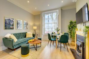 a living room with a green couch and a table at Portland Street Leamington Spa Apartments in Leamington Spa