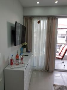 salon z telewizorem z płaskim ekranem na komodzie w obiekcie M & M White Luxury w Paralii Katerinis