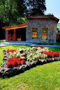 a house with a garden with flowers in front of it at Berloga in Rodnikovka