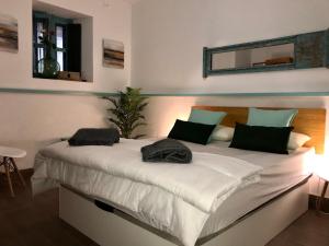 - une chambre avec un grand lit blanc et des oreillers verts dans l'établissement S27 Corral del Siglo XVI, à Séville