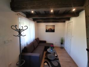 Vali néni kifőzde és apartman في Kismaros: غرفة معيشة مع أريكة وطاولة