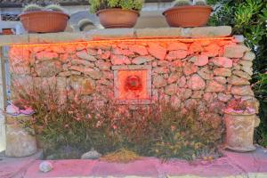 a stone wall with a red fire hydrant at Residence Villa Grotta Monaca in Otranto