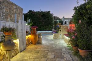 a garden with vases of flowers and a white fence at Residence Villa Grotta Monaca in Otranto