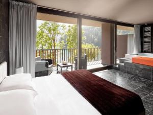 a bedroom with a large bed and a balcony at NS SUITE SAURIS in Sauris