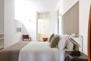a hotel room with a bed, chair, and nightstand at Casa Balthazar in Lisbon