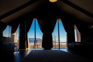 a room with large windows with a view of the desert at Dachi Holiday home in Volzhskiy