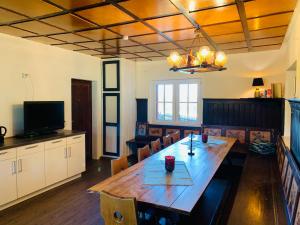 ein Esszimmer mit einem Holztisch und Stühlen in der Unterkunft Baude Steinheid am Rennsteig mit 12 Betten in Steinheid