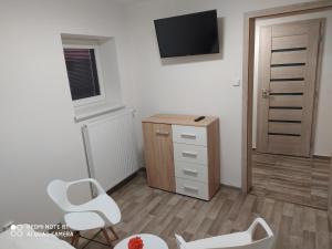 una camera con due sedie, una scrivania e una televisione di Apartmán u Davida a Hlohovec