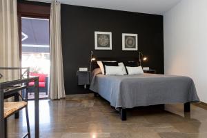 1 dormitorio con cama y pared negra en Casa Los Cuatro Soles, en Córdoba