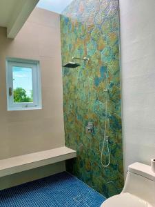 a bathroom with a shower with a mosaic tile wall at Villa del Carmen Boqueron in Cabo Rojo