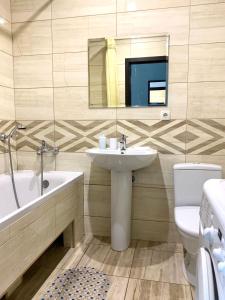 a bathroom with a sink and a tub and a toilet at Blue apartments on Kotsyubinsky Avenue in Vinnytsya +26 photos
