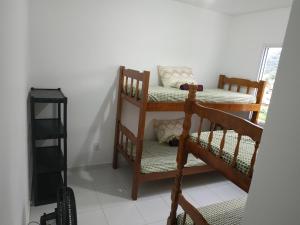a room with two wooden bunk beds and a window at Pausa da Correria nesta estadia I in Caraguatatuba