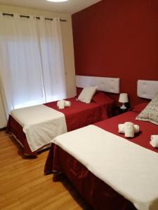 a bedroom with two beds with red and white sheets at Guesthouse RSA by Umbral in Almancil