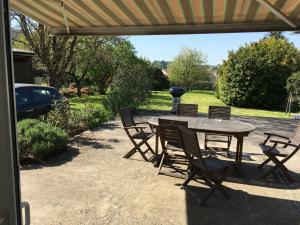 a patio with a table and chairs and a grill at chambre salle de bain partagée in Cognac