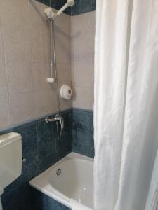 a bathroom with a shower and a white shower curtain at Guesthouse RSA by Umbral in Almancil